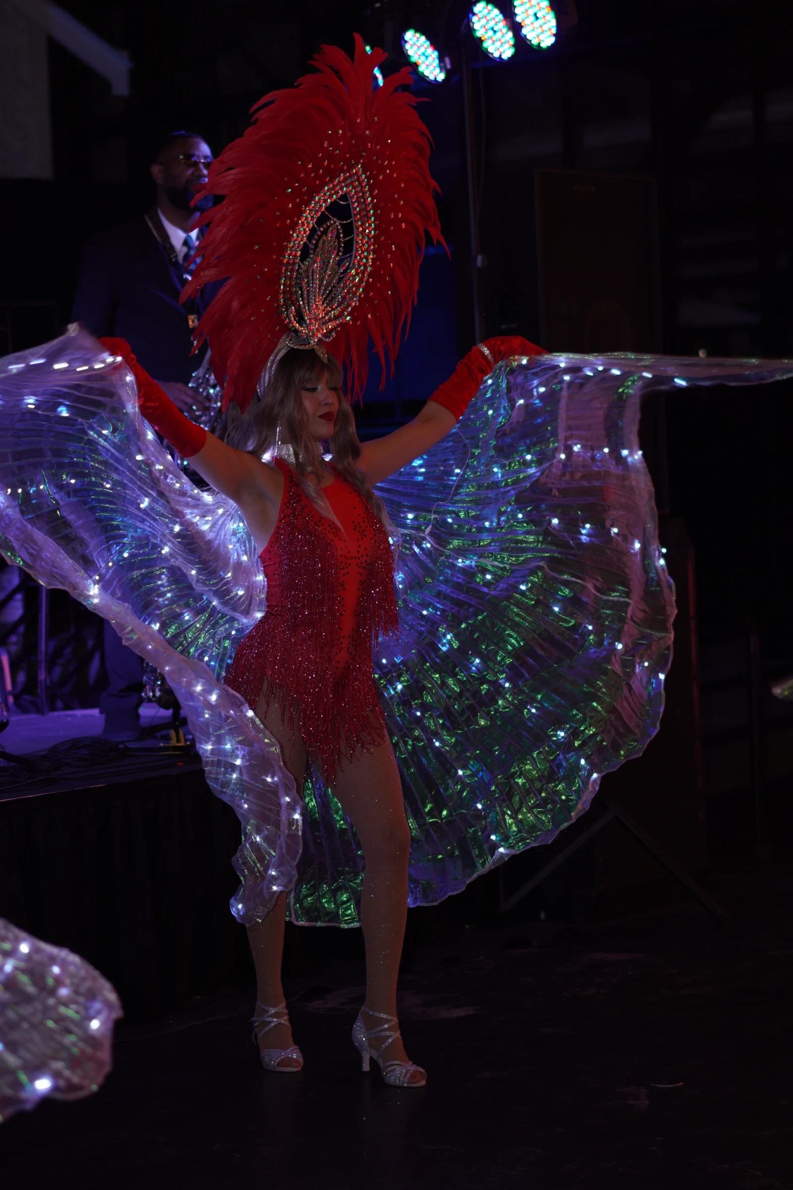 Queen of Hearts performer posing beneath theatrical lighting