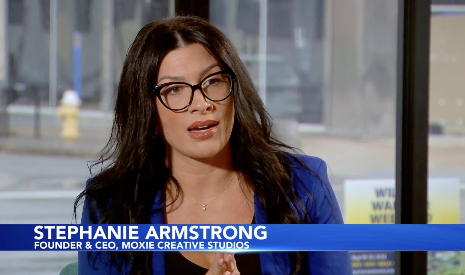 Stephanie Armstrong speaking on News10NBC, with her name and Moxie Creative Studios shown on screen